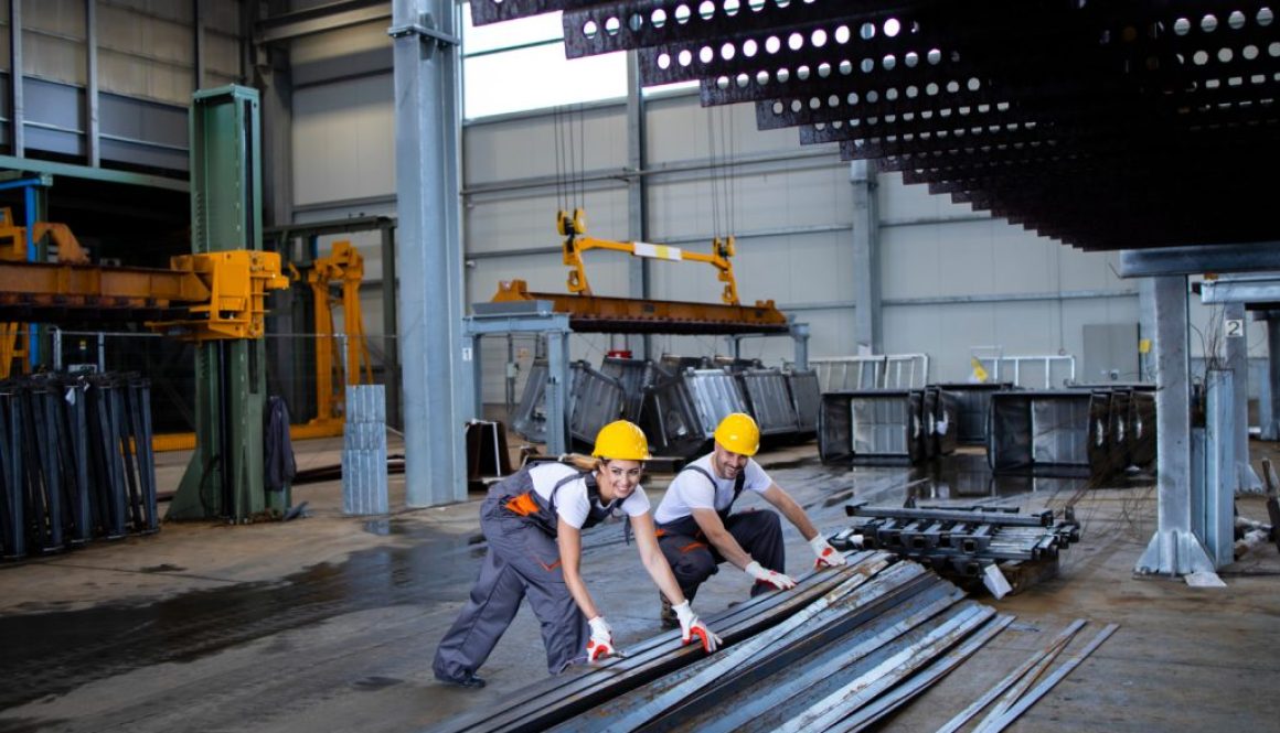 factory-workers-handling-metal-parts-together