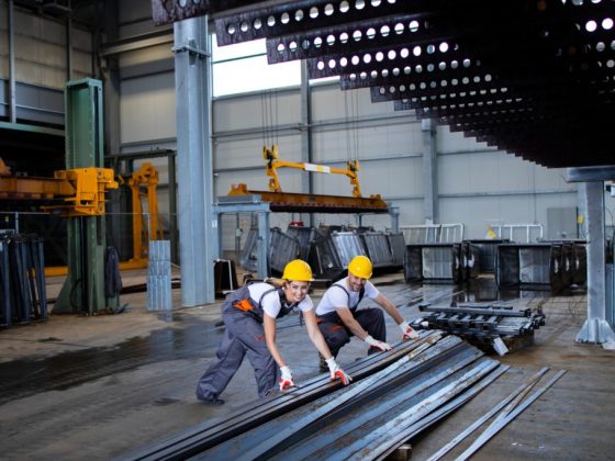 factory-workers-handling-metal-parts-together